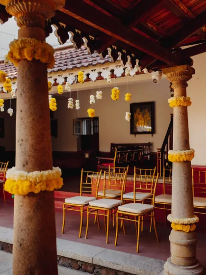 Traditional stone pillars decorated with marigold garlands for a Haldi ceremony.