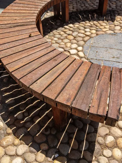 A detail shot of the craftsmanship in the curved benches, made from upcycled wood. This highlights our commitment to circular design and finding beauty in repurposed materials.
