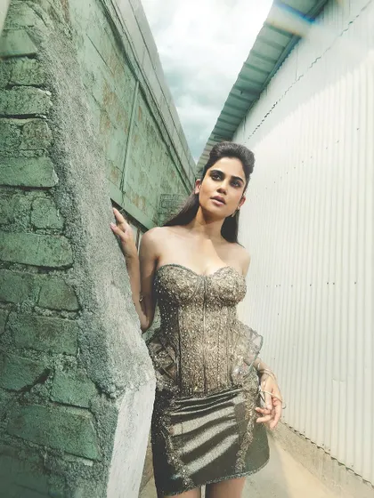 Another angle of the metallic editorial look. This shot shows the contrast between the raw, industrial background and the high-fashion styling and makeup.