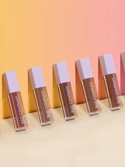 A simple yet visually pleasing lineup of "Bad Company" liquid lipsticks. The diagonal arrangement and hard shadows on a multi-toned background create a sense of rhythm and make the colors pop.