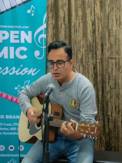 An adult student singing and playing guitar at the HSR branch open mic. My classes and events are for music lovers of all ages.