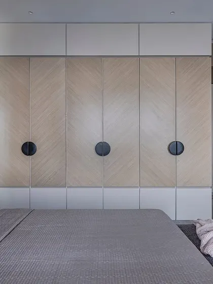 A full view of the bedroom in 'Aria Residence', showing the interplay between the red headboard, the patterned veneer on the wardrobes, and the grey marble flooring.