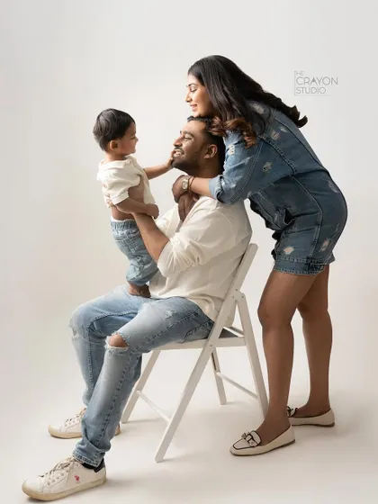 A beautiful composition of a family of three, showing their interaction and connection in a relaxed studio pose.