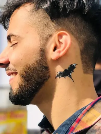 A cool bat silhouette temporary tattoo on the neck. This is great for a Halloween party or for anyone who loves a gothic vibe.