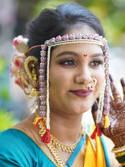 The beauty of a Maharashtrian bride lies in the details. This close-up highlights the flawless makeup, the intricate mundavalya, and the traditional nath, all coming together to create a divine look.