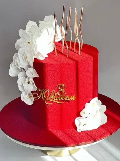 Another view of the vibrant red cake, showing the contrast between the rich color and the delicate white florals.