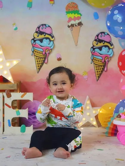 A precious portrait before the cake smash, showing off the colorful ice cream theme with balloons and fun props.