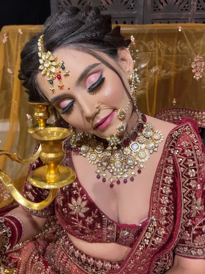 The richness of a velvet bridal lehenga calls for equally luxurious makeup. This look features deep, sultry eyes and a perfectly contoured base, creating a regal and unforgettable appearance for the bride's D-Day.