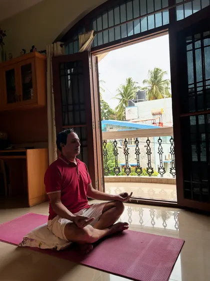 A client finds stillness and focus in Sukhasana (Easy Pose) during a guided meditation as part of his personalized home yoga plan.