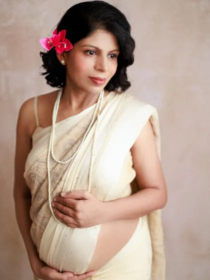 A pensive, beautiful portrait of an expecting mother. Her hand rests on her belly, a gesture full of love and a heart full of anticipation for the little one inside.