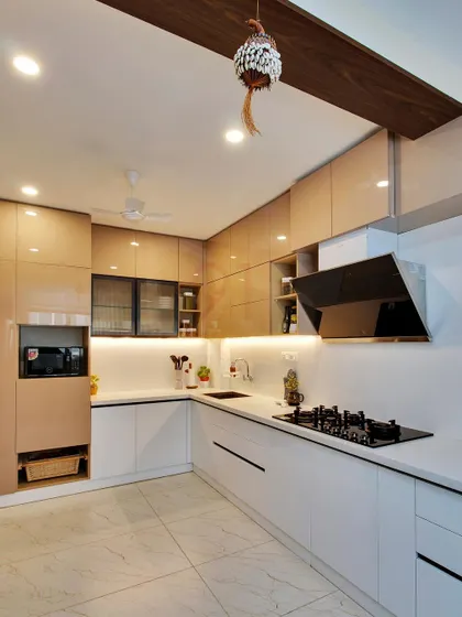 A premium acrylic finish kitchen with a two-tone design of beige and white, featuring handle-less Gola profile shutters for a sleek look.