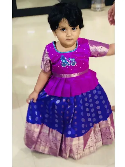 I love mixing traditional fabrics with modern styles. This Pattu Pavadai features a trendy peplum top over a classic silk skirt, and I added a custom bicycle embroidery for a personal, whimsical touch.