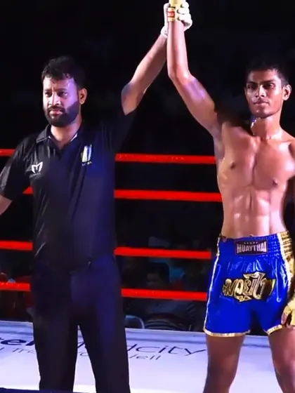 The referee raises our fighter's arm in victory at the WMC National Muay Thai Championship.