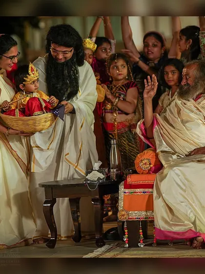 A tender moment during the Janmashtami celebration, where a young child dressed as baby Krishna is presented to me. It is a beautiful reminder of the divine innocence within all of us.