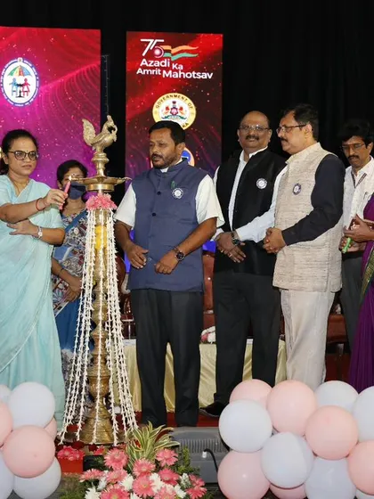 The ceremonial lamp lighting at the International Adoption Month event, a key moment we facilitated on a stage decorated with flowers and balloons.