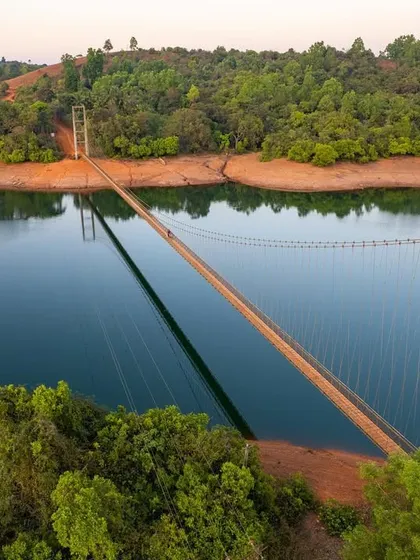 A hanging bridge over a serene river in the Western Ghats. These bridges are lifelines for local communities, connecting remote areas.