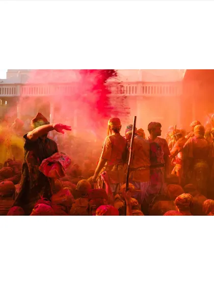 A devotee throws colored powder over the crowd during Holi celebrations. The air becomes thick with color, creating a hazy, dreamlike atmosphere that I love to photograph.