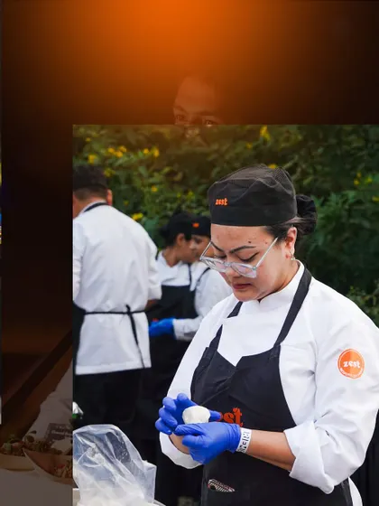A female chef carefully preparing dumplings, showcasing the diversity and skill of our team.