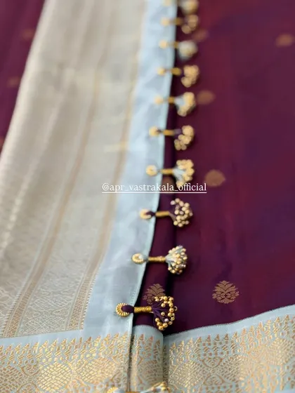 The back of the blouse features delicate tassels to complement the artwork.
