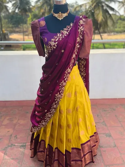 A yellow and purple half saree with puff sleeves and an embroidered dupatta.