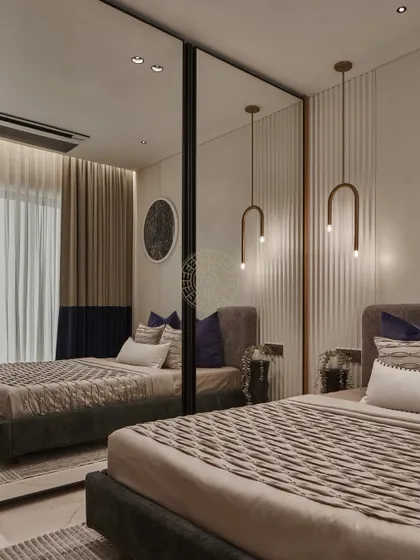 In this bedroom, we used mirrored closet doors to make the space feel larger and brighter. The reflection shows the room's design, including the fluted wall paneling and the signature blue accents in the curtains.