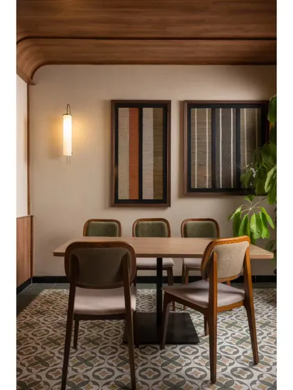 Another angle of the four-person dining table, highlighting the texture of the chairs and the geometric pattern of the floor tiles. Every element was chosen to contribute to a warm and inviting atmosphere.