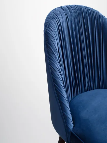 A close-up of the pleated back, showcasing the meticulous craftsmanship and the way the light catches the folds of the velvet.
