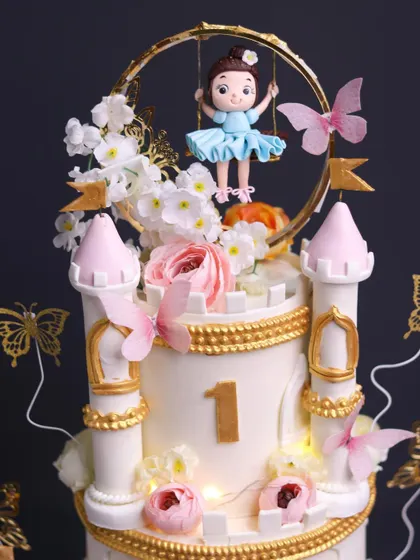A close-up of the enchanting details on the swinging doll castle cake, highlighting the delicate flowers, golden accents, and tiny lights.