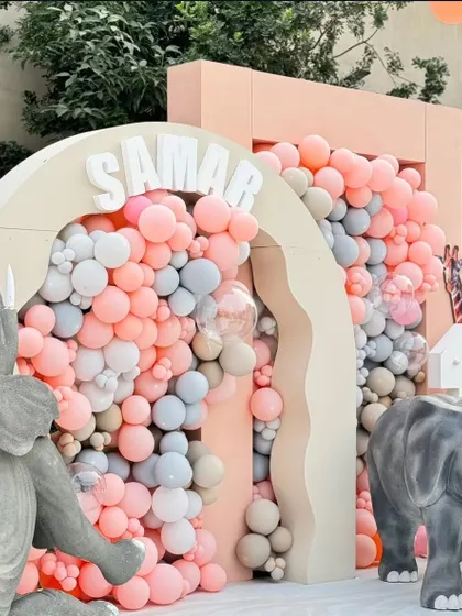 A close-up of the balloon-filled archway, showcasing the soft color palette of pink, grey, and beige that defined this chic and modern jungle theme.