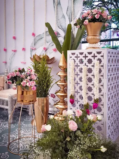 A close-up of the traditional decor, showing the intricate "jaali" panel, brass lamp, and beautiful floral arrangements.