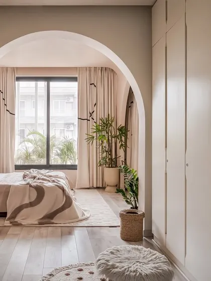 An archway frames the view into the bedroom, showcasing the layered design and the seamless flow from the wardrobe area to the sleeping space.