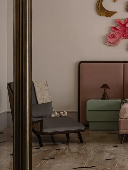 A peek into the junior master bedroom, showing the Cane Crush lounge chair and the corner of the bed with its pastel-colored side table.