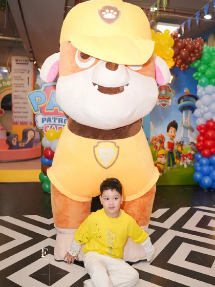 The birthday boy gets a picture with a life-sized Paw Patrol mascot, a highlight of his themed party.