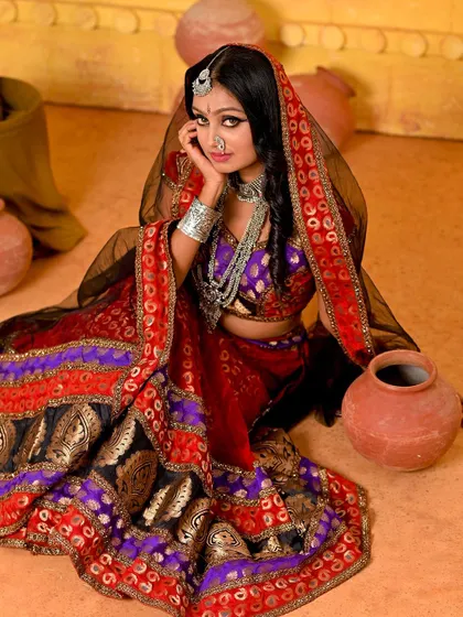 A seated pose from the Rajasthani series, conveying a sense of waiting and contemplation. The composition draws the eye to the intricate details of the traditional attire and the emotive expression of the model.