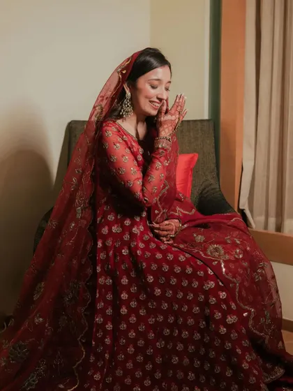 A shy, happy smile from this beautiful bride. Her minimal makeup for this function perfectly suits her elegant red attire.