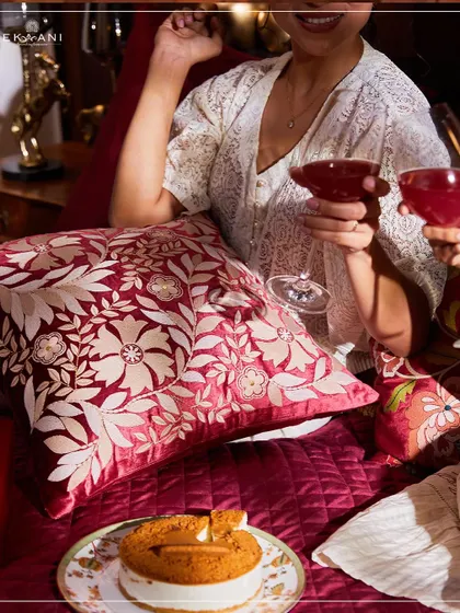Experience the essence of elegance with my Anardana collection. This lifestyle shot captures a cozy moment with a rich, red floral cushion, embodying the opulence and artistry of the collection.