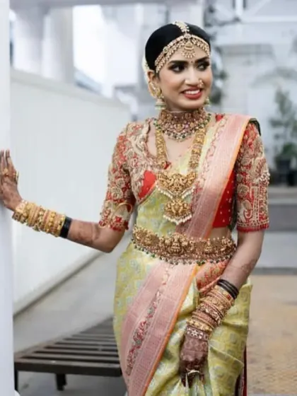 A full-length shot of a bride in her stunning Kanchipuram saree, showing how the makeup, hair, and traditional attire create a cohesive and royal look.
