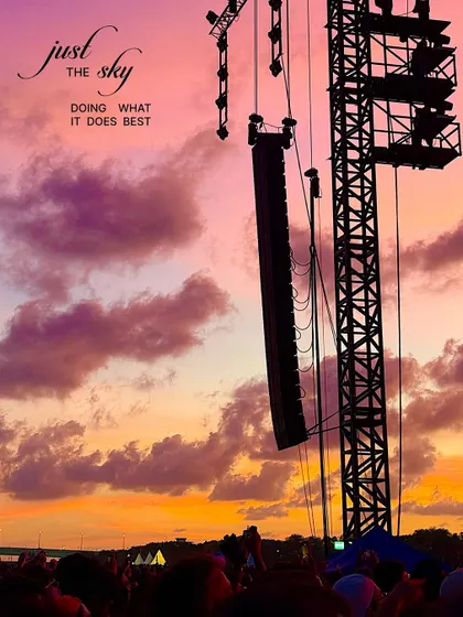 The sky doing what it does best. A dramatic sunset with purple and orange clouds seen from a music festival.