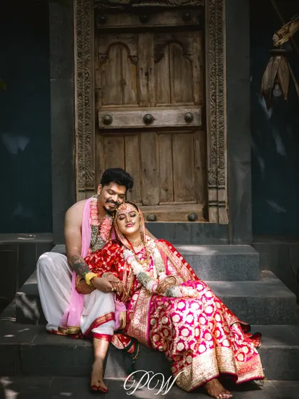 A quiet moment of love after the ceremony. The bride and groom, in their beautiful traditional attire, find a peaceful spot on the steps, showcasing the calm after the grand celebration.