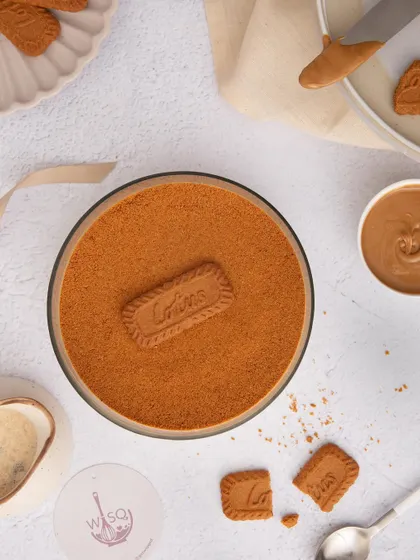 A top-down artistic shot of our Biscoff Tiramisu, surrounded by Biscoff biscuits and spread, highlighting the key ingredient.