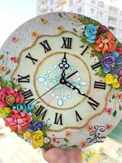 The full view of the 14-inch clock, held to display its balanced composition and vibrant floral arrangements.