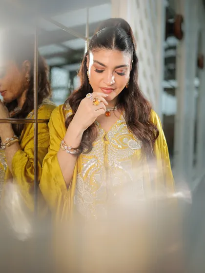 An artistic shot with a dreamy, soft-focus effect. The makeup looks ethereal and beautiful, highlighting her features.