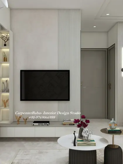 The TV unit in this 2BHK is simple and clean, with a floating console and a backlit display niche. The design prioritizes function without sacrificing style.
