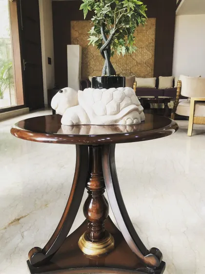 This classic side table is crafted from solid wood with a polished finish. Its traditional pedestal base and round top make it a versatile piece that can be used in a living room, bedroom, or entryway.