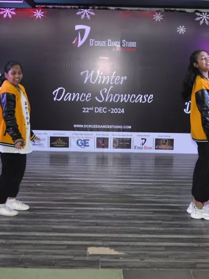 A duet performance at the Winter Dance Showcase 2024, with dancers in stylish varsity jackets.