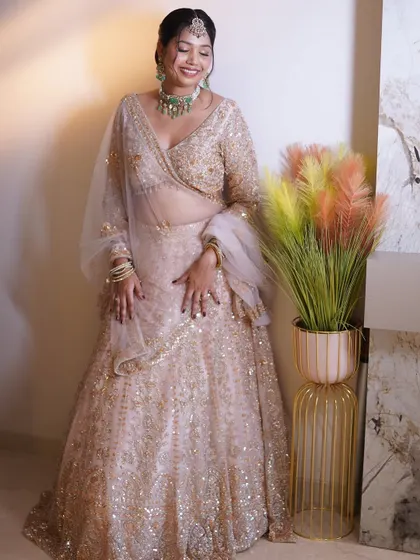 Bridal beauty is a celebration. This bride is radiant in her beige and gold lehenga, with makeup that celebrates her, not transforms her.