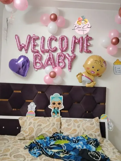 A simple 'Welcome Baby' girl room decoration with foil letters and character cutouts.