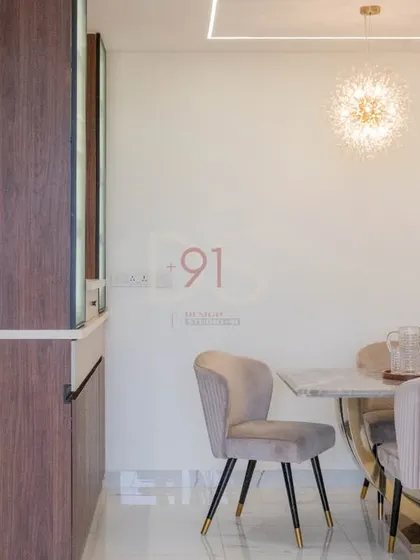 A side view of the dining area, showing the custom crockery unit and the linear lighting design on the ceiling.