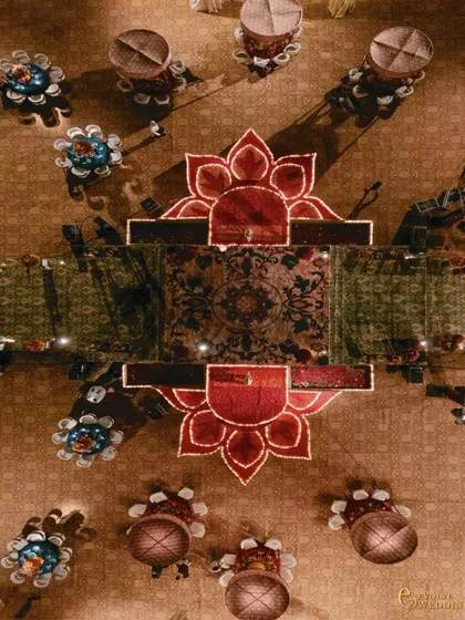 An aerial detail of the 16-foot rangoli, crafted from shola flowers and candles, forming a sacred centerpiece along the grand aisle. This demonstrates my commitment to integrating traditional artistry into large-scale designs.