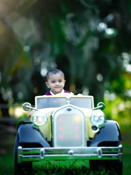 A little driver enjoys the open air in his vintage toy car. Our outdoor sessions allow for fun action shots like this.
